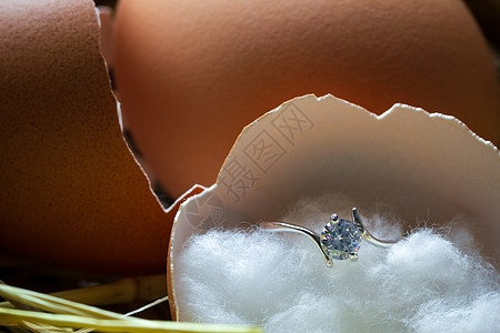 生鸡蛋鸡蛋壳里的假钻石戒指 和早安一起破在卵巢上背景