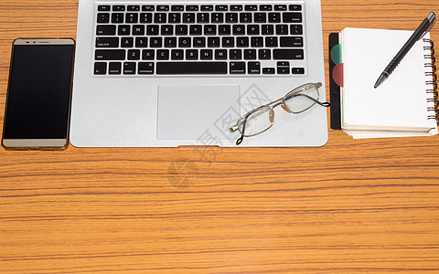 办公桌上有开放式笔记本 手机 眼镜的办公桌 带复制空间的顶视图 商业静物概念与桌上的办公用品 教育 工作或规划概念键盘技术教学待图片