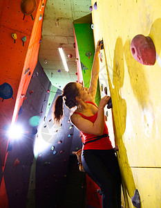 活跃的年轻女性在爬上健身房时 在多姿多彩的人工岩石上挥舞 极端运动和室内攀登概念闲暇风险锻炼挑战行动登山者力量登山巨石成人图片