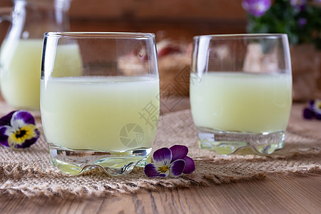 两杯新鲜的鲜花 配着雀巢花乡村水壶牛奶木头饮食液体营养玻璃奶制品食物图片