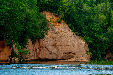 河流沿岸的红沙石悬崖爬坡树木风景瀑布远足溪流旅游木头假期地标图片