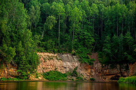 拉脱维亚有河流 悬崖和森林的景观爬坡岩石反射荒野树木远足环境旅游旅行峡谷图片