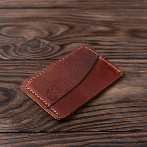 Ginger手工制作的皮革 木本底的一个口袋持卡人 盘面照片 背景模糊软图片