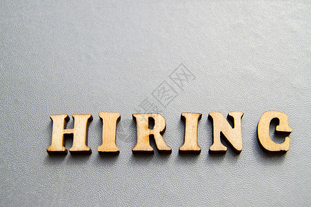 hiring广告招聘的用词是HIRING 由灰色背景的木字母制成 为设计师准备的布局求职者文本小样资源职业劳动力木板管理创造力人员背景