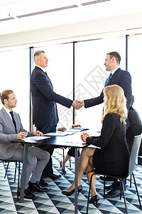 工商界人士的握手男人经理文档生意桌子伙伴笔记本交易团队电脑图片