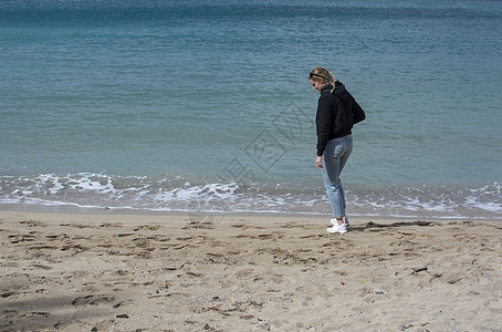 年轻可爱的女人 在春天沙滩上散步蓝色晴天海岸假期海滩支撑旅行天空海洋乐趣图片