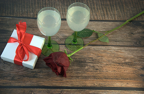 木桌上两杯香槟玫瑰和礼盒玫瑰盒子周年植物群酒杯桌子木头夫妻生日礼物图片