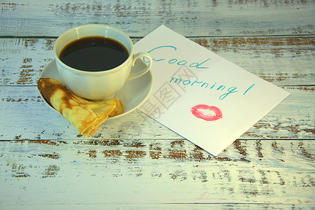 茶碟上的一杯咖啡 新鲜出炉的煎饼和一张写着早安心愿并涂了一丝口红的纸金子食物陶瓷恋爱海报杯子贴纸桌子飞碟愿望图片