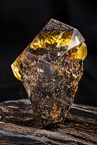 天然琥珀石 一块肮脏的琥珀 在一块石头上有透明的黄色层化石晴天抛光宝藏地质学反射材料矿物宏观珠宝图片