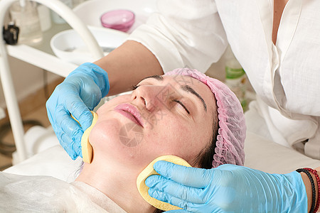 美容院的年轻女子在超声波剥皮后 做皮肤湿润手术卫生保湿美容师奶油女性呵护治疗胶原护理程序图片