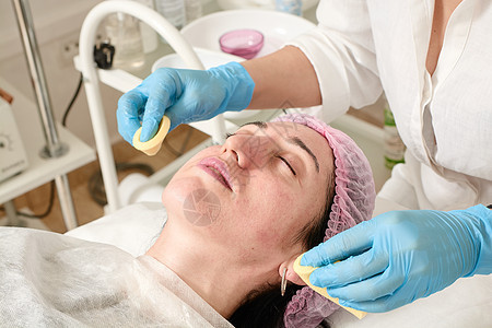 美容院的年轻女子在超声波剥皮后 做皮肤湿润手术乐趣治疗化妆品沙龙呵护程序美容口罩皮肤科女士图片