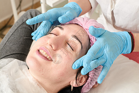 年轻女性在美容院做专业的面部按摩福利脖子美容保湿温泉皮肤科保健程序享受皮肤图片