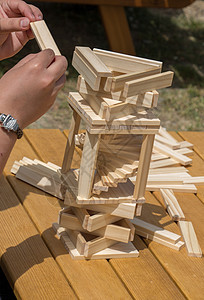 手持木制拼图元素在汉挑战智力合作头脑解决方案知识乐趣学习建造团队图片