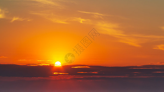 太阳的光芒在云中穿透天空 阳光照耀着日落 明亮的橙色日落气氛地平线晴天辉光橙子射线全景天堂横梁背景图片