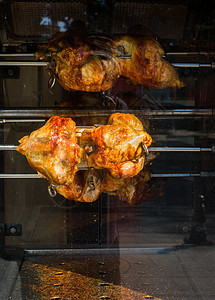 在展示中用金属旋转的金属烤鸡烘烤玻璃棕色黄色炙烤屠夫街道烹饪店铺皮肤图片