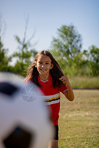 踢足球女孩玩小女生游戏青年选择性女性女孩焦点运动员绿色孩子们微笑橙子背景