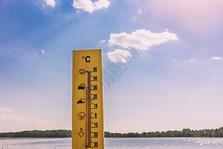 显示 30 摄氏度热量的温度计以湖水和蓝天为背景在阳光下气候旅行预报天空环境状况热带摄氏度游泳假期图片