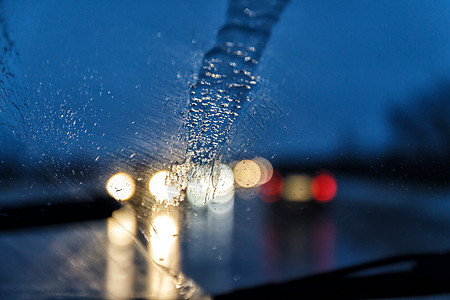 在下雨的晚上透过汽车的挡风玻璃拍照运输季节街道雨滴车辆风暴运动水器蓝色交通图片