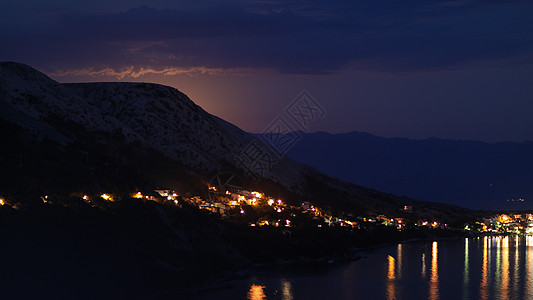 月光下的夜景从克罗地亚的岩石山到亚得里亚海沿岸的城市 不同的色调游客地标建筑建筑学旅行海景航行公寓港口风景图片