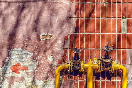 高楼墙上的管道上有两个黄色的阀门压力控制工程危险预防力量金属管子消防栓建造图片