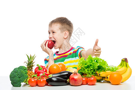 快乐的男孩在饮食与食物 吃一个红苹果坐在图片