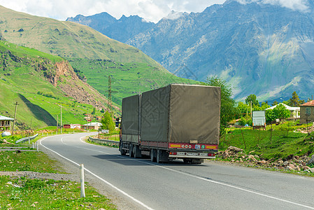 高加索山区公路上载有货物的拖车尾车厢图片