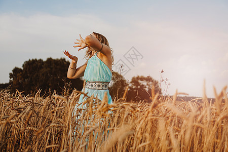 美丽的女青年在现场舞蹈中跳舞女孩光环花朵喜悦日落农场生活裙子自由日出图片