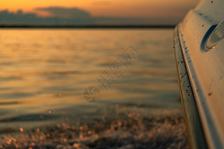 日落时从船上抽出水来天空蓝色海浪地平线阳光速度海洋反射旅行旅游图片