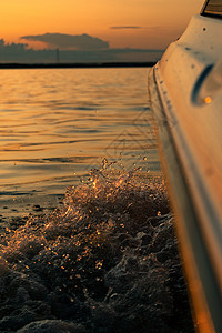 日落时从船上抽出水来支撑地平线天空蓝色阳光反射海滩海浪海洋旅游图片