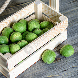 木箱里绿壳里的胡桃果子的青绿色果实化妆品盒子灰色核桃酊剂绿色叶子医疗民间食谱图片