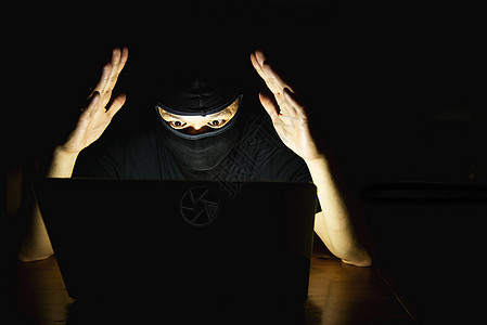 电脑黑客在暗室里用笔记本电脑工作  有电脑犯罪概念的人药剂病人男性药片处方药品剂量女性男人治疗图片