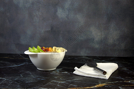 健康的早餐 一杯咖啡燕麦片 水果片和勺子在白餐巾纸上图片