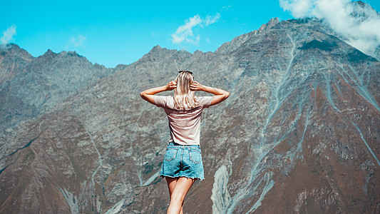 女人在阳光明媚的白天在山上远足图片