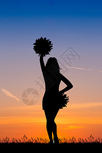 日落时的啦啦队员轮钟吉祥物学校跳跃女士太阳日落团队大学欢呼绒球图片