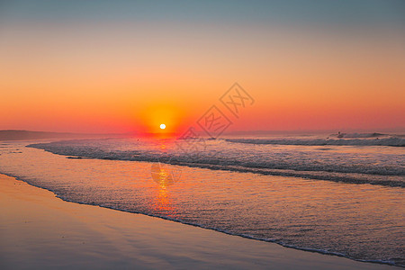 橙色日落太阳海岸线日出海岸地平线反射蓝色晴天海洋场景图片