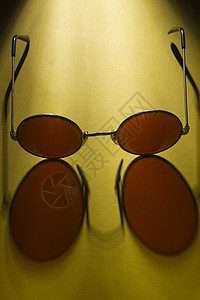 黄色表面的圆太阳镜黑色圆形阴影反射桌子眼镜镜片框架潮人图片