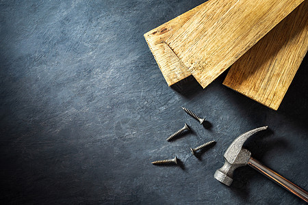 黑水泥背景上的锤子和木材 顶视图和复制维修工作木工控制板木头工具装修金属工艺木板图片