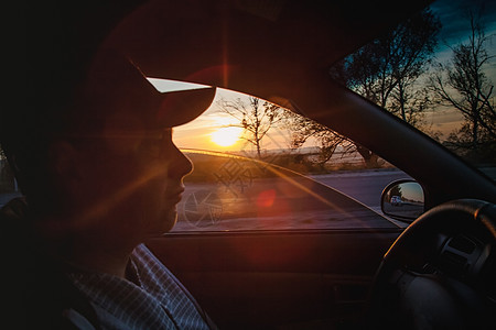 概念 公路旅行和旅行 迁徙自由 在日落 特闭 模糊不清时驾驶汽车的男子太阳商业车辆技术控制板方向盘享受控制速度镜子图片