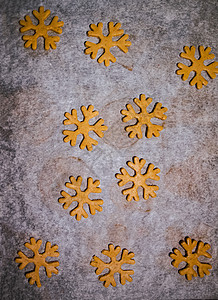 姜饼饼干切成雪花的形式 由生面团在深色背景的羊皮纸烘焙纸上制成 从上面看 节省空间滚动卡片柜台男生团体星星孩子明信片用具八角图片