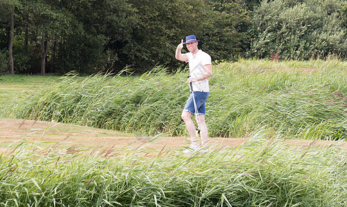 Golfer在高尔夫球场上举起大拇指图片