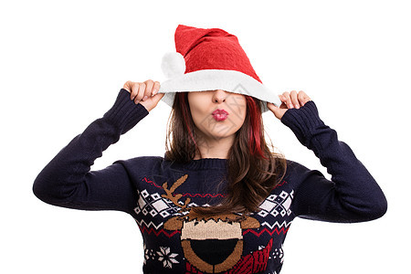 一个女孩的肖像 将圣诞老人的帽子戴在她的眼睛上图片
