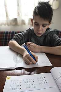男孩做功课男生铅笔学习学校桌子白色童年写作青年教育图片
