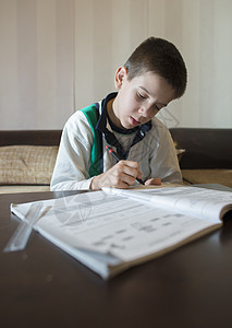 孩子做他的功课 手握笔 男孩学习铅笔幼儿园儿子男生孩子们桌子童年写作学生白色图片
