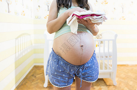 孕妇在婴儿房公寓房间母性婴儿床母亲裙子家庭卧室父母怀孕图片