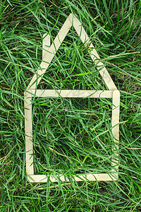 复古木制背景在绿草上建造的样板房框架白色生态销售商业绿色草地住宅建筑贷款背景