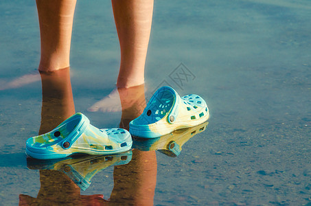 露水中的橡皮拖鞋漂浮在女性双腿旁边的清水中 紧闭u女士池塘方向运动夫妻反射游泳一部分女孩图片