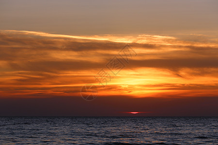 阴云的日落辉光天空太阳海景地平线戏剧性艺术橙子旅行水平图片