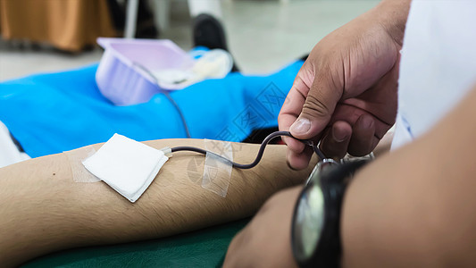为交叉红色组织献血的志愿者  有献血观念的人康复管子捐款注射器病人手臂捐赠者静脉治疗男性图片