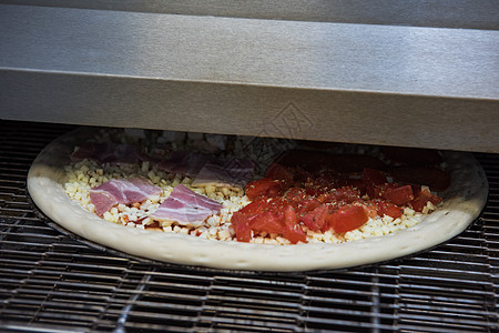 在烤箱里准备比萨饼厨师食物披萨脆皮燃烧壁炉厨房食谱烹饪餐饮图片