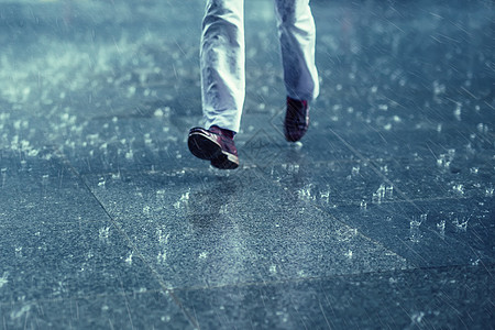 在人行道上下雨 在雨水中奔跑者图片